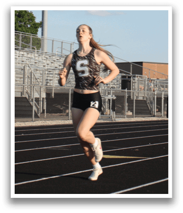 A woman is running on a track in front of a crowd of people. Contenido generado con IA