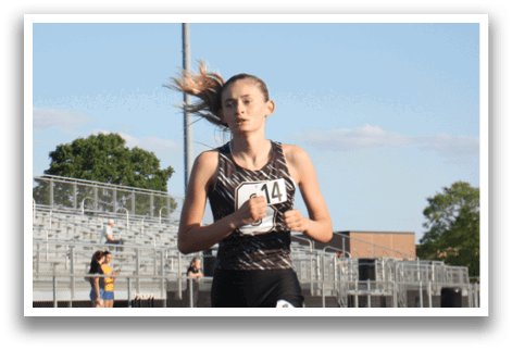 A woman is running on a track with her hair blowing in the wind. Contenido generado con IA