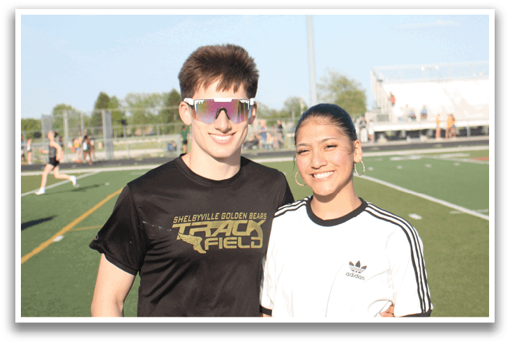 Two people standing on a field, one wearing a black shirt and the other wearing a white shirt. Contenido generado con IA