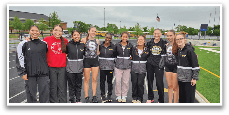 A group of female athletes pose for a photo on a track. Contenido generado con IA