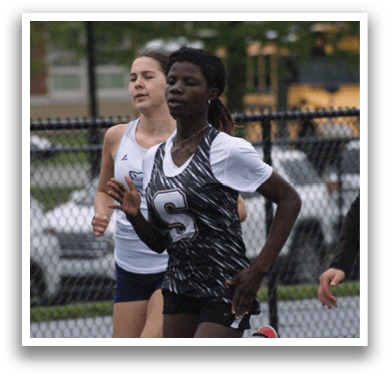 Three girls are running on a track, wearing uniforms. Contenido generado con IA