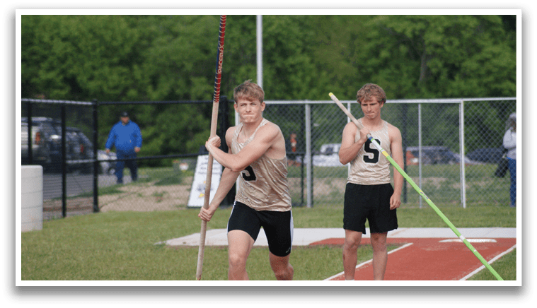 Two men are standing on a track, holding poles and preparing to throw them. Contenido generado con IA
