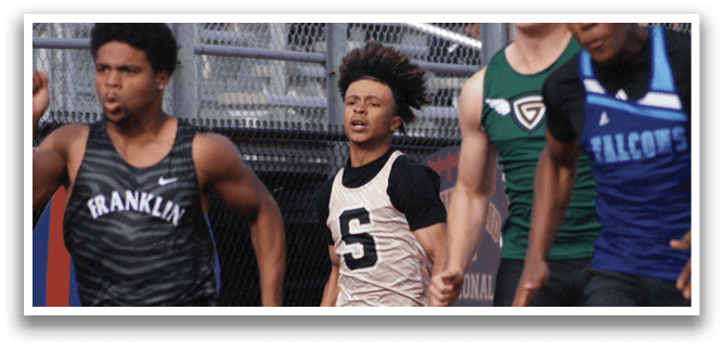 A group of young men are running on a track, with one of them wearing a black shirt and the others wearing blue and green. Contenido generado con IA
