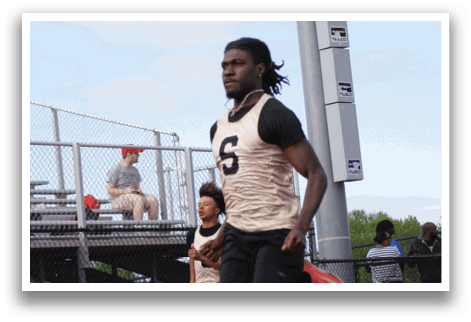 Two young men are running on a track, one wearing a number 5 jersey. Contenido generado con IA