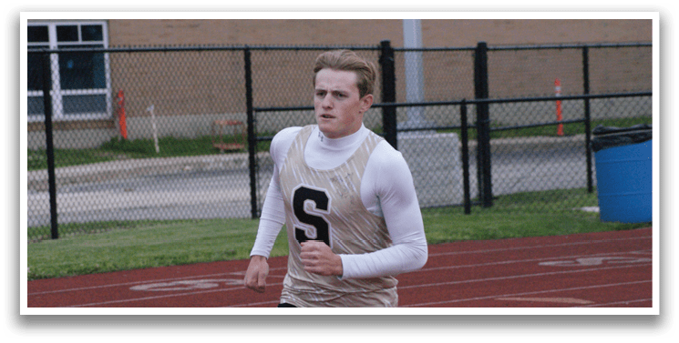 A man wearing a white and gold track suit is running on a track. Contenido generado con IA