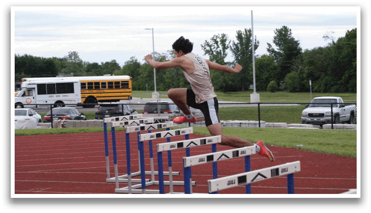 A man is jumping over a barrier on a track. Contenido generado con IA