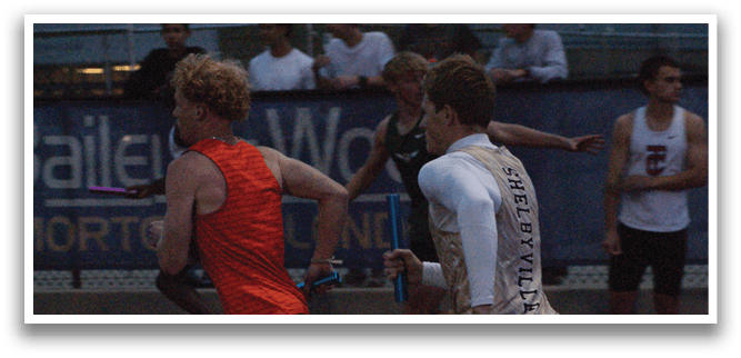 Two men are running on a track, one wearing an orange shirt and the other wearing a white shirt. Contenido generado con IA