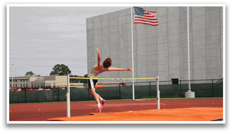 A woman is jumping in the air on a track, attempting to clear a hurdle. Contenido generado con IA