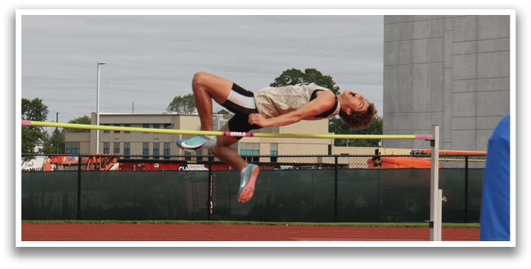 A man is jumping over a pole in a track and field event. Contenido generado con IA