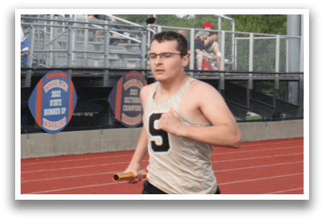 A man is running on a track while people watch from the stands. Contenido generado con IA