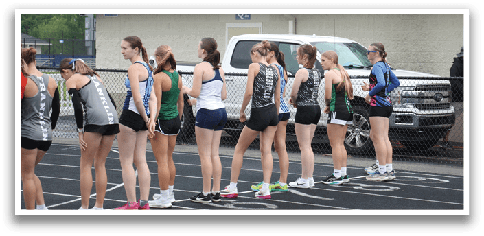 A group of female runners are lined up on a track, preparing to run. Contenido generado con IA