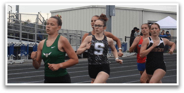 A group of girls running on a track, with one girl leading the pack. Contenido generado con IA