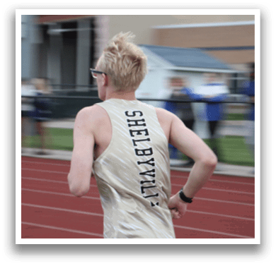 A man wearing a gold and white shirt is running on a track. Contenido generado con IA