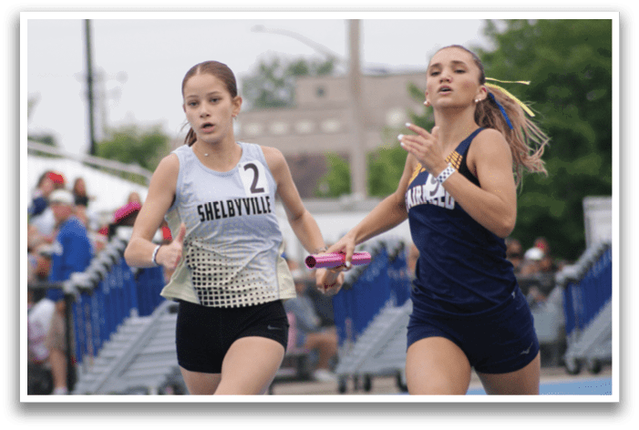 Two female athletes running on a track, one wearing a white shirt and the other wearing a blue shirt. Contenido generado con IA