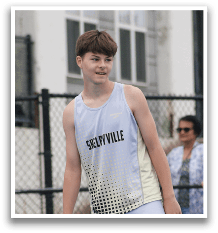 A young man wearing a white and black track suit stands on a field. Contenido generado con IA