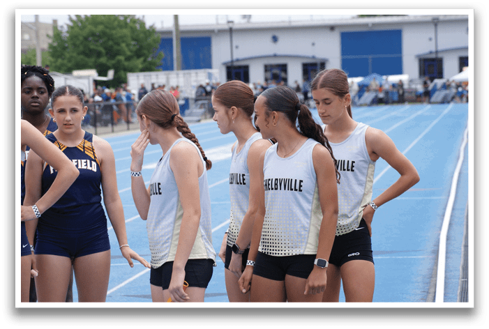 A group of female athletes wearing uniforms and sunglasses stand on a track. Contenido generado con IA