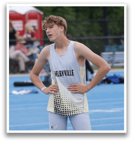 Three young men are standing on a track, wearing athletic clothing. One of them is wearing a white and black outfit, while the other two are wearing black and yellow outfits. They are all looking in the same direction, possibly at an event or competition. Contenido generado con IA