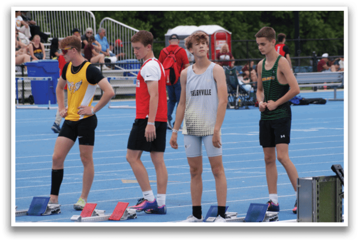 A group of young men are standing on a track, wearing shorts and waiting for the starting gun. Contenido generado con IA