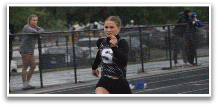 A woman wearing a black shirt and shorts is running on a track. Contenido generado con IA