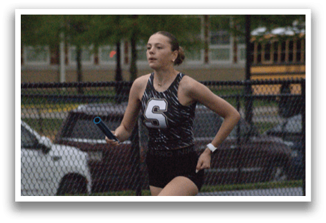 A woman running on a track with a watch on her wrist. Contenido generado con IA
