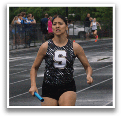 A woman is running on a track with a crowd of people watching. Contenido generado con IA