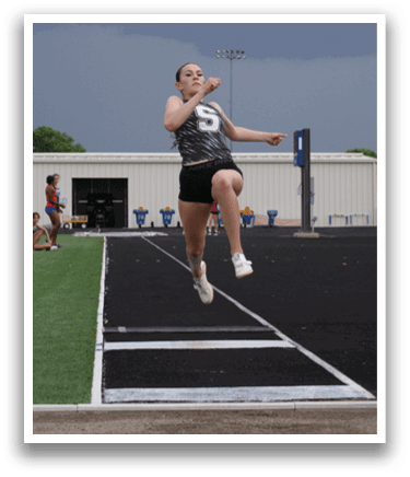 A woman is jumping in the air on a track, wearing a black and white outfit. Contenido generado con IA