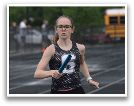 A woman running on a track with a blue frisbee in her hand. Contenido generado con IA