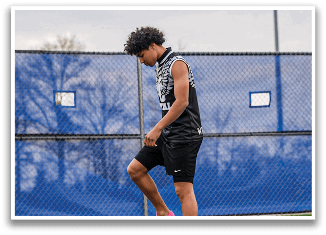A person wearing pink shoes and black shorts is walking on a track. Description generated by AI