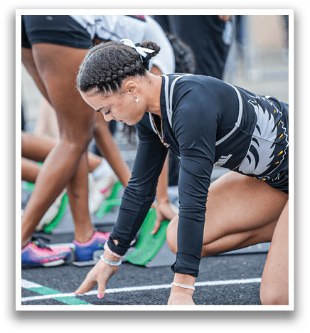 A woman bending over to touch a line on a track. Description generated by AI