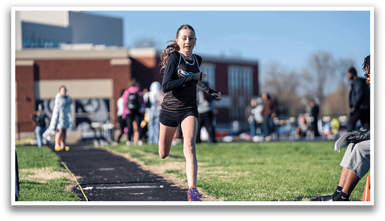 A girl running on a track. Description generated by AI