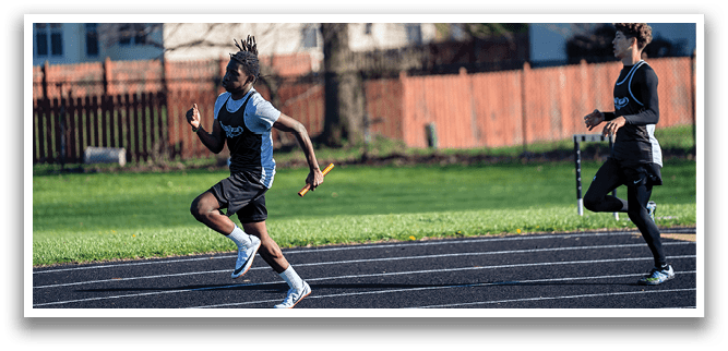 A man running on a track with a yellow object in his hand. Description generated by AI