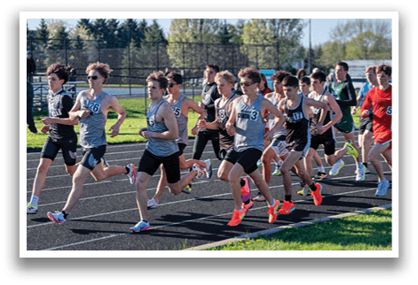 A group of young men running on a track. Description generated by AI