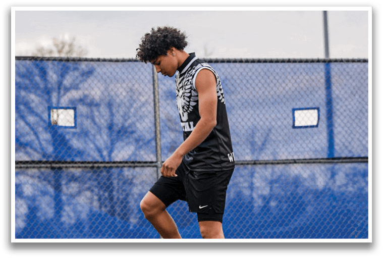 A person wearing pink shoes and black shorts is walking on a track. Description generated by AI