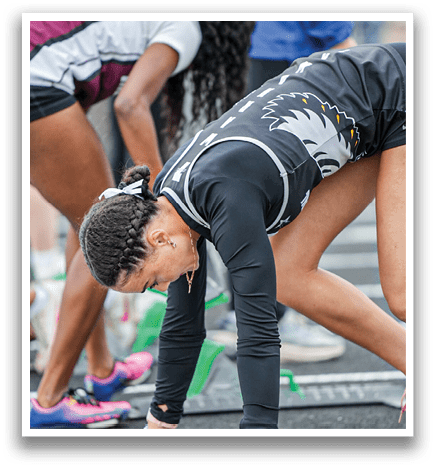 A woman bending over with a green and white track. Description generated by AI