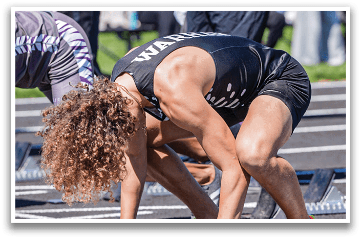 A man wearing a black and white shirt and red shoes is bending over to touch a white line on the ground. Description generated by AI
