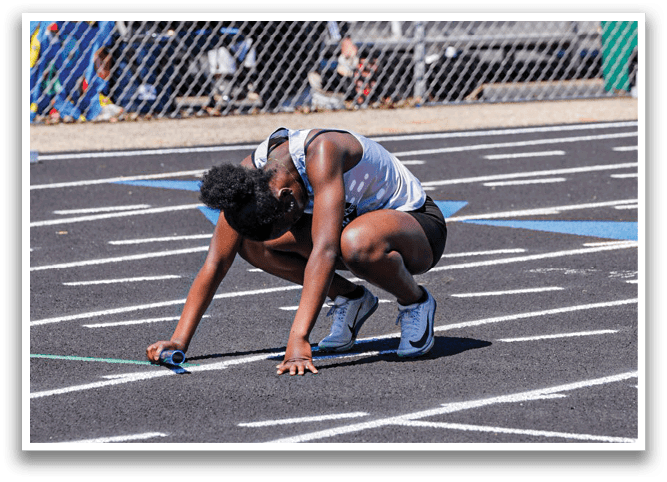 A person is bending over on a track. Description generated by AI