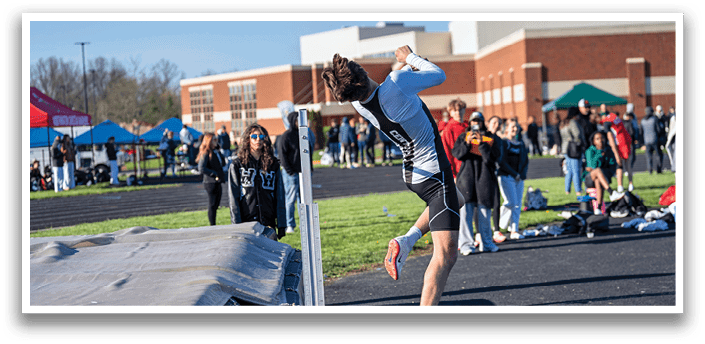 A man jumping over a barrier. Description generated by AI