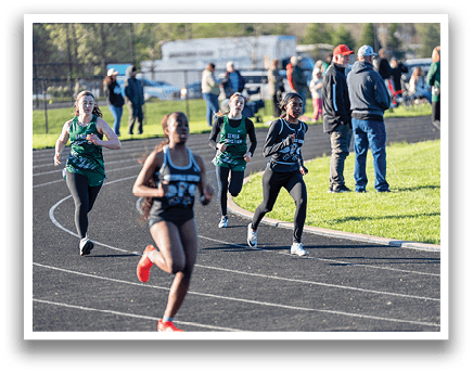 A group of girls running on a track. Description generated by AI