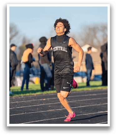 A man running on a track. Description generated by AI
