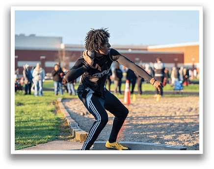 A man in a black shirt and striped pants is holding a pair of weights. Description generated by AI