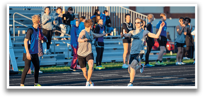 A group of people running on a track. Description generated by AI