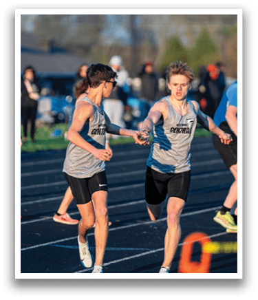 A group of people running on a track. Description generated by AI