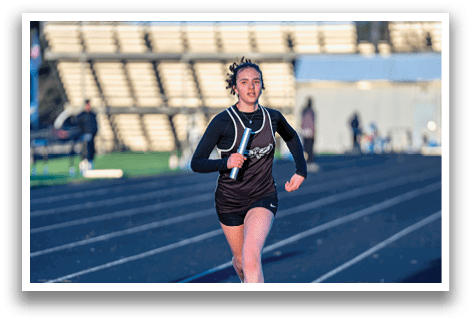 A woman running on a track. Description generated by AI