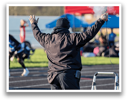 A man in a black jacket and black hat is standing on a track. Description generated by AI