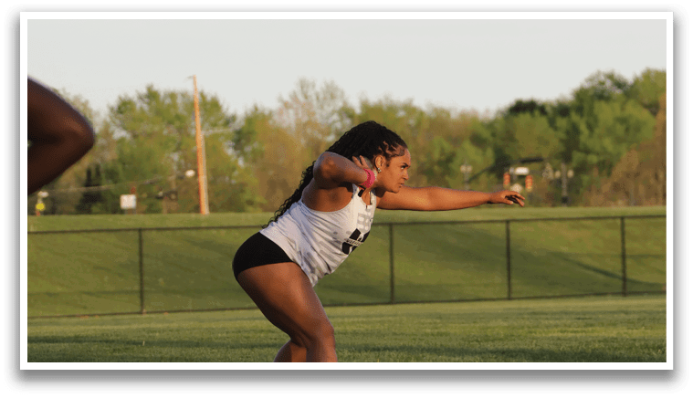 A woman is bending over on a field. Description generated by AI