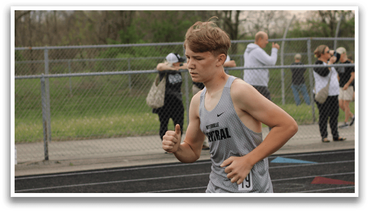 A man running on a track. Description generated by AI