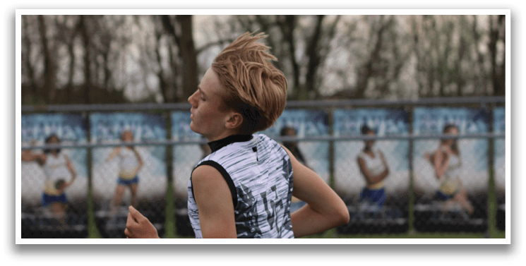 A boy running on a track. Description generated by AI