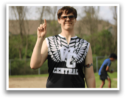 A man wearing a black and white shirt with a white arrow on it. Description generated by AI