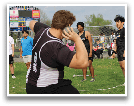 A man wearing a black shirt and black shorts is bending over. Description generated by AI