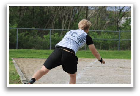 A man in a black shirt and white shorts is throwing a disc. Description generated by AI